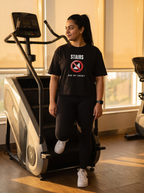 Stairs Are My Enemy box fit gym t shirt for women in Black, worn by a model glaring at a stair climber machine