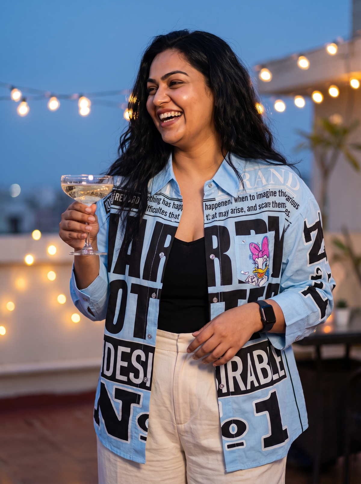Breaking News oversized Kora cotton shirt in sky blue, worn open at a rooftop party at dusk