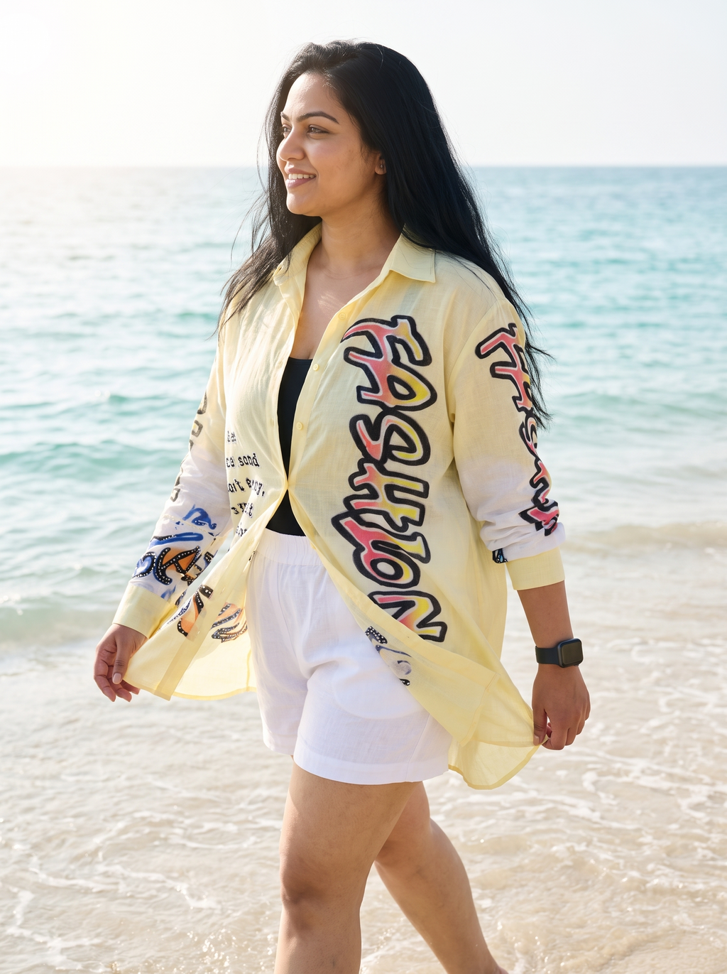 Front Page oversized Kora cotton shirt in butter yellow, worn open as a beach layer in the waves