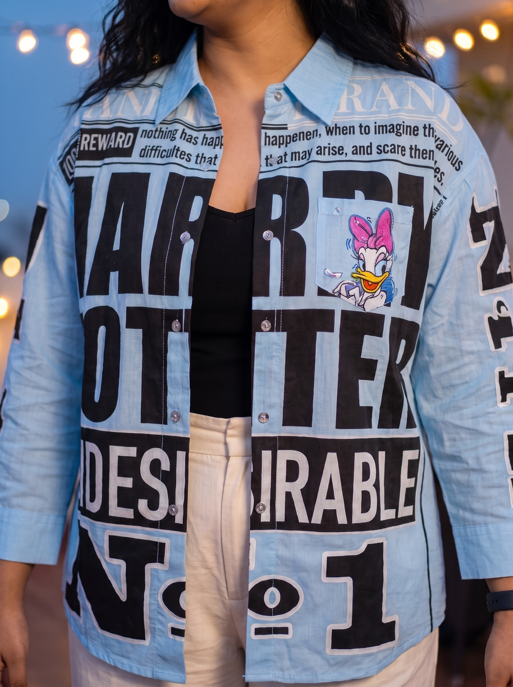 Zoomed front view of the Breaking News oversized Kora cotton shirt worn open showing the chest print