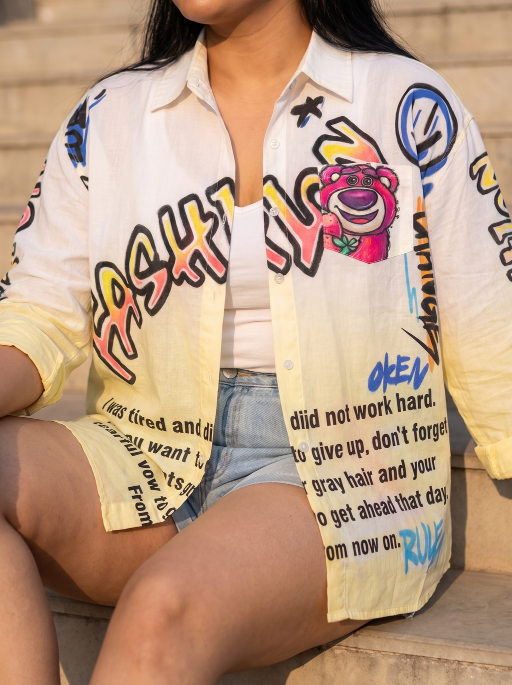 Zoomed front view of the Change oversized Kora cotton shirt worn open showing the graffiti print