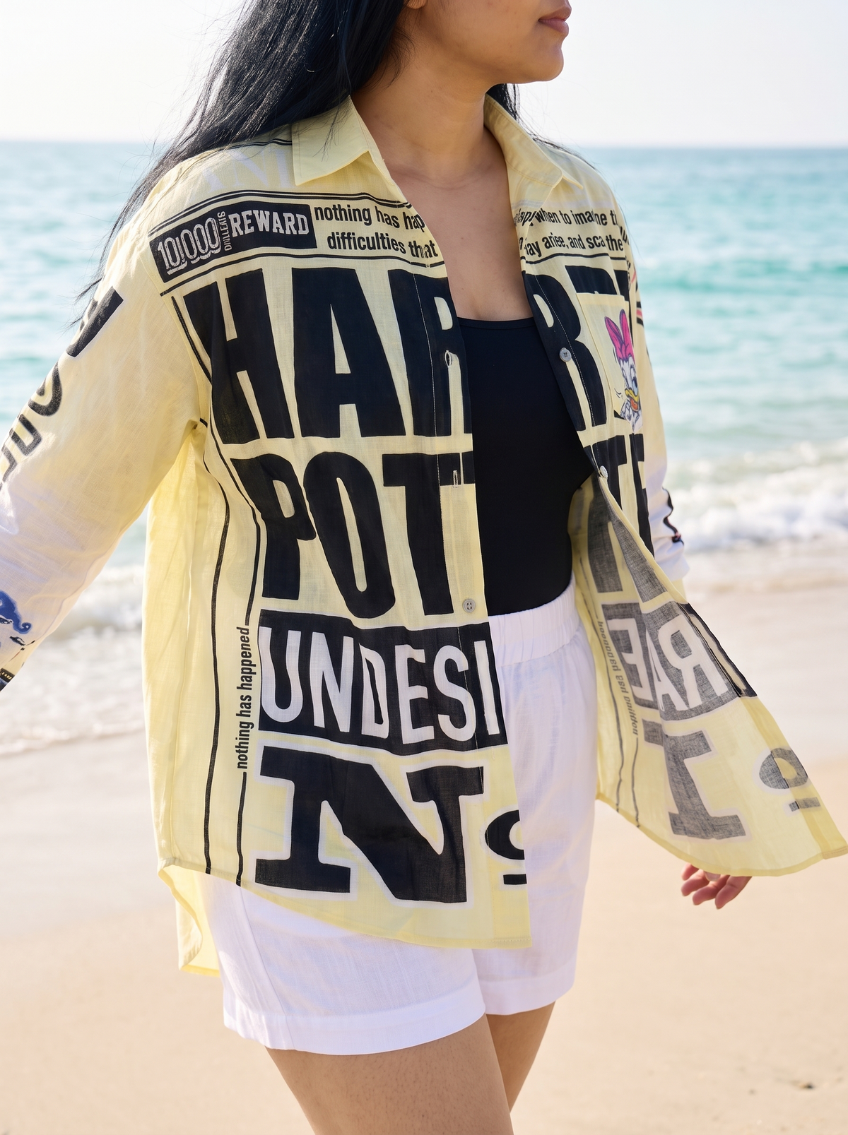 Zoomed front view of the Front Page oversized Kora cotton shirt worn open showing the newsprint panels