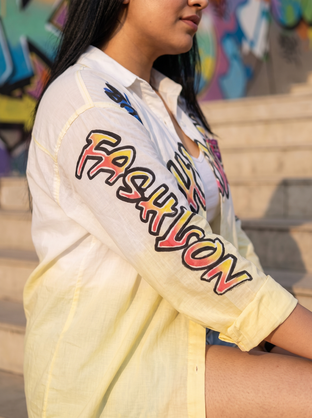 Sleeve detail of the Change oversized Kora cotton shirt showing the graffiti lettering