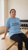Claude, Do My Cardio tee in sky blue, worn on a gym bench